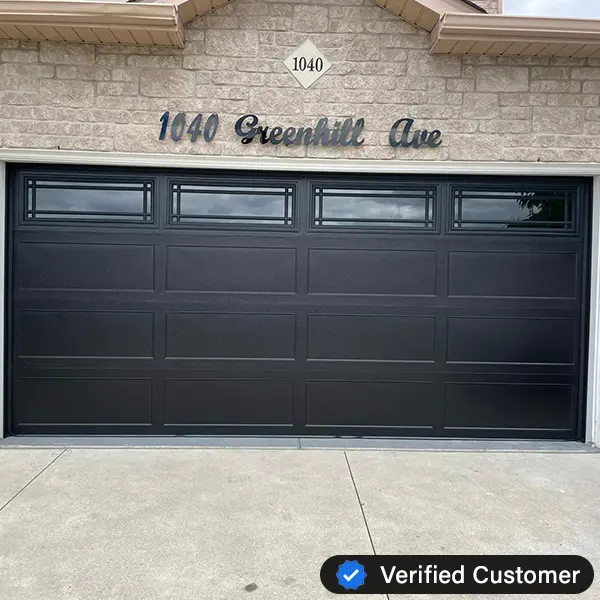 verified-garage-door-repair A modern black garage door with rectangular windows at the top, set in a brick house at 1040 Greenhill Ave. A Verified Customer badge and a Garage Door Repair service highlight appear in the bottom right corner.