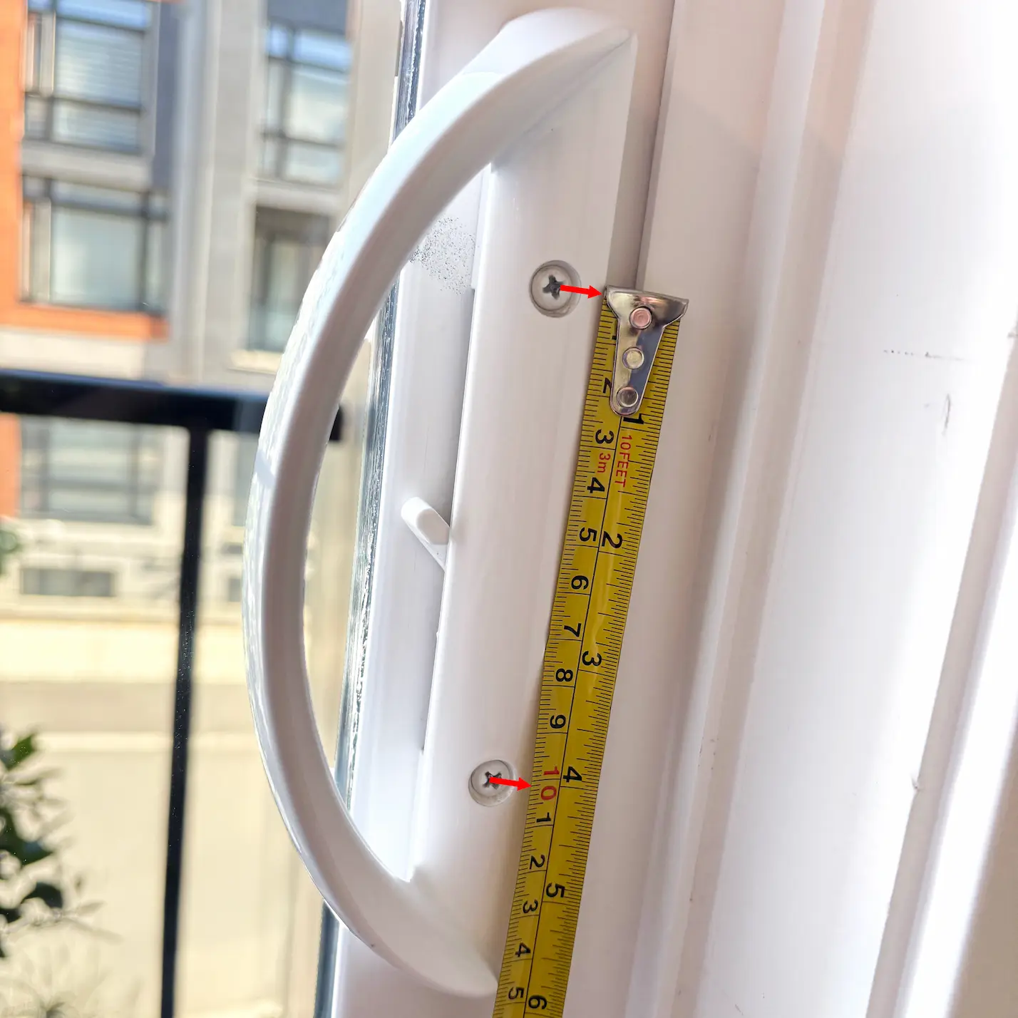 this image shows how how to measure a sliding door handle hole to hole with a measuring tape